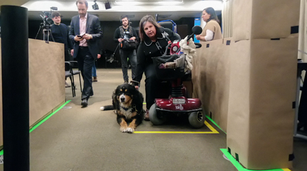 Une femme en quadriporteur accompagnée de son chien d'assistance teste la configuration des futurs autobus d'Exo